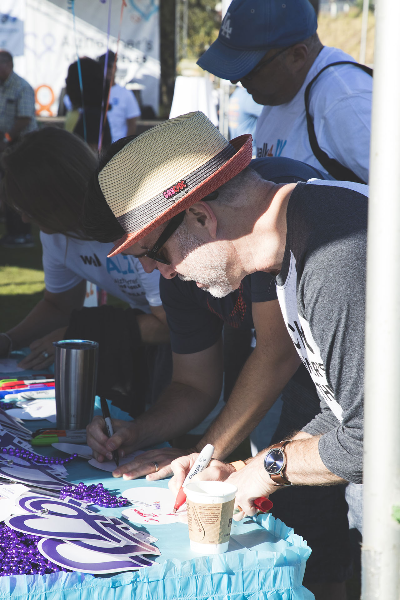 participant writing name on an honor heart