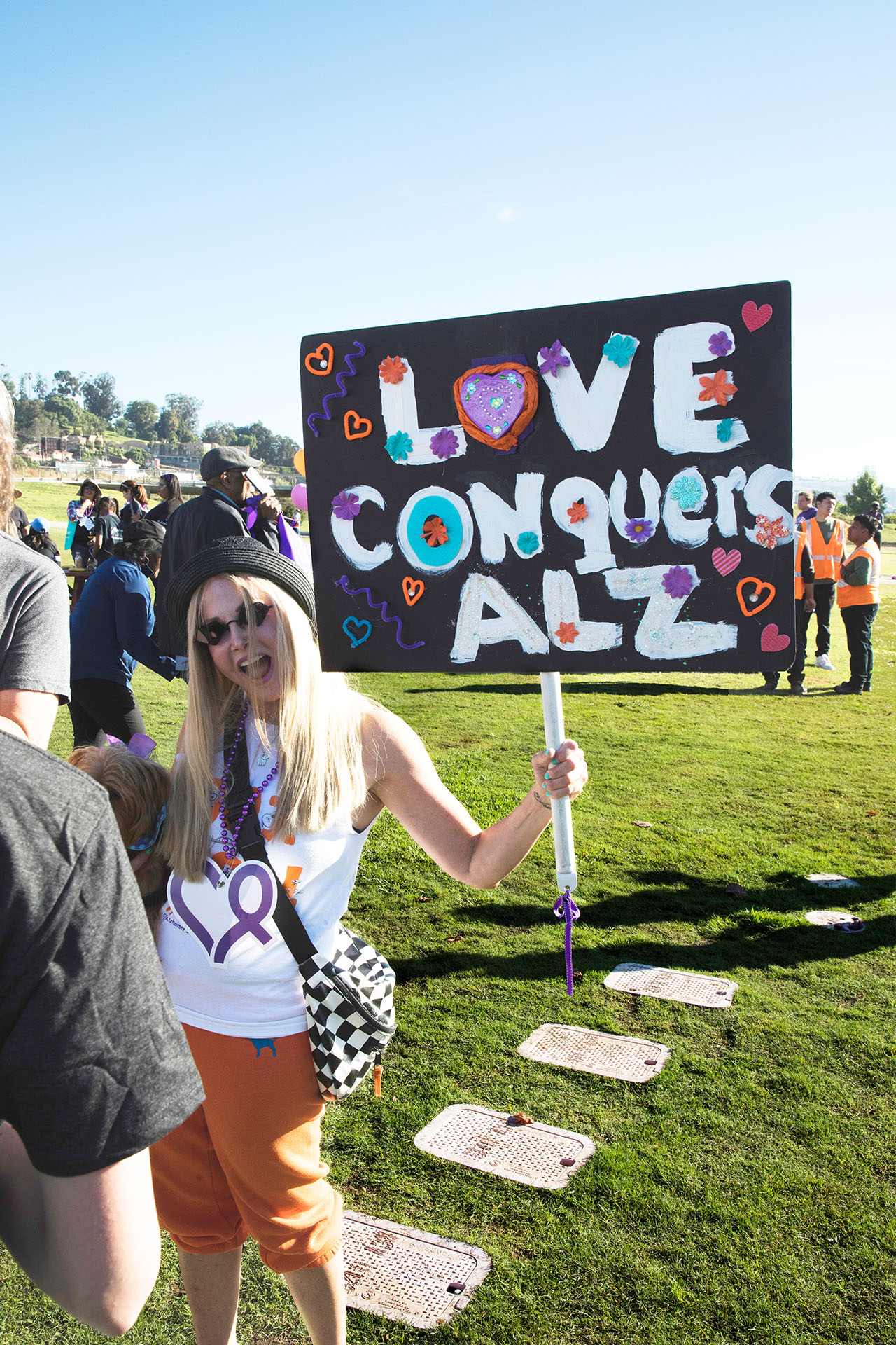 walker holding "Love conquers ALZ" sign