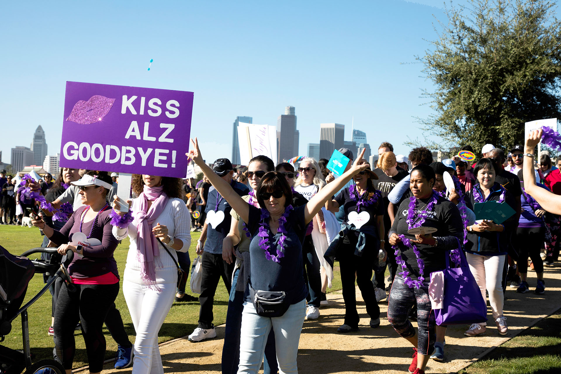 walkers holding "Kiss ALZ goodbye" sign