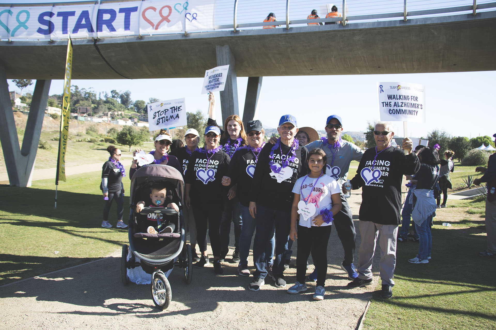 a family of walkers pose in front of the start banner