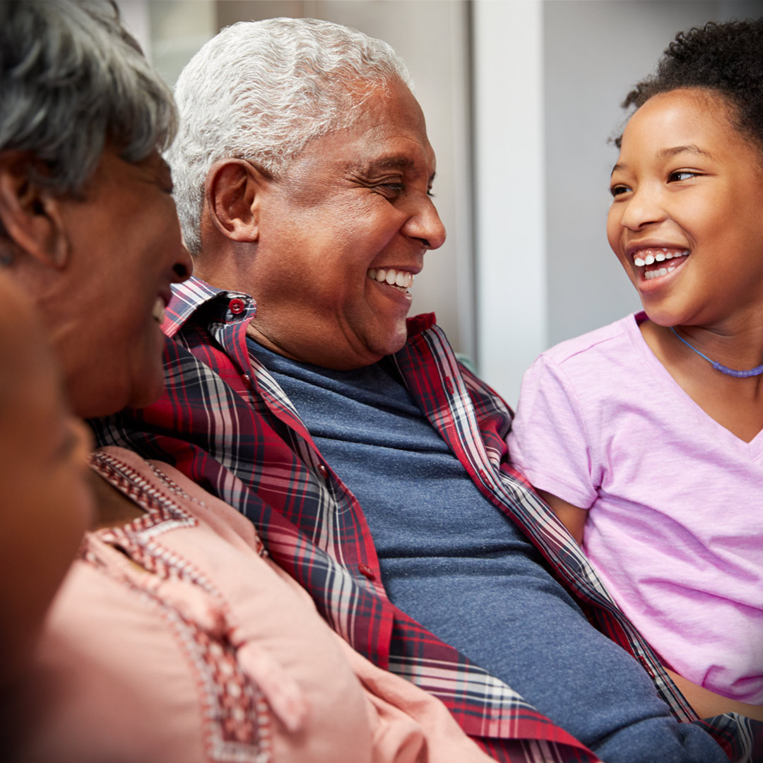 grandparents laughing together with grandchildren at home