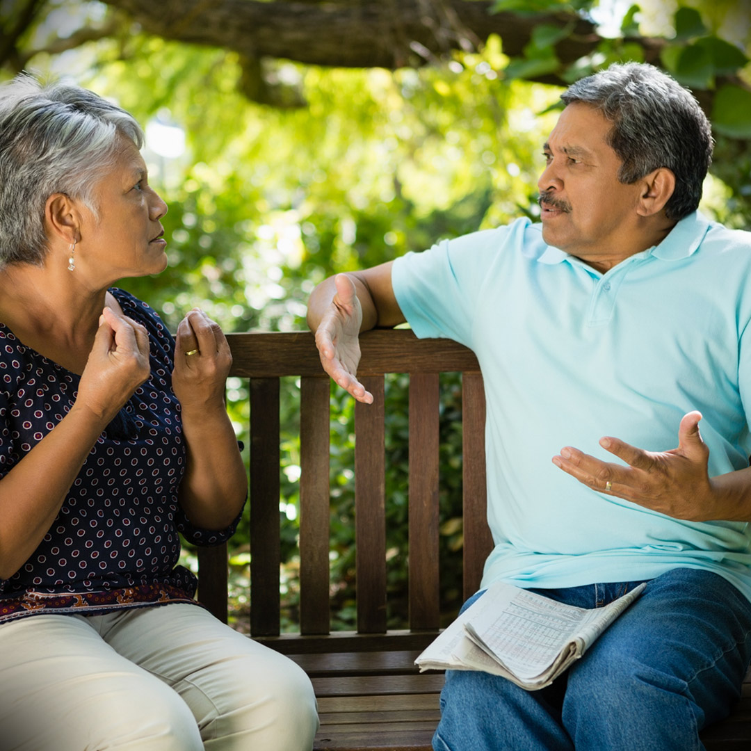 couple sitting on a park bench and arguing