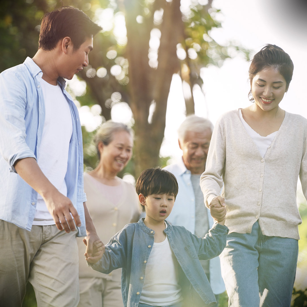 multigenerational Asian family walking in park