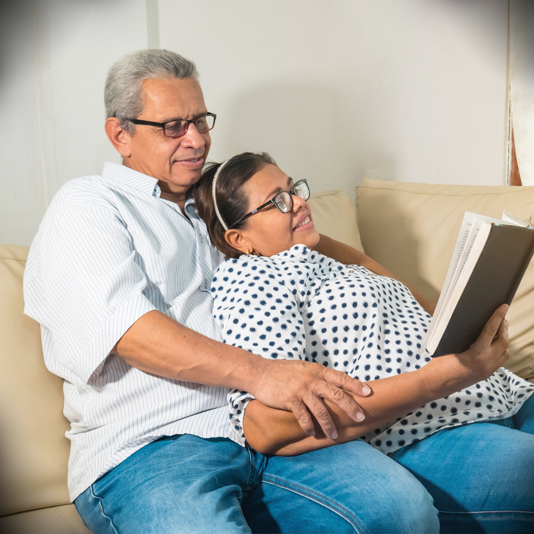 man and woman on couch reading book together