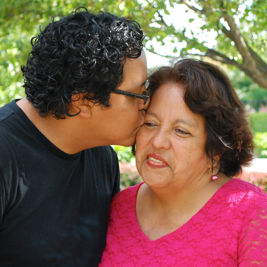 adult son kissing mother on forehead