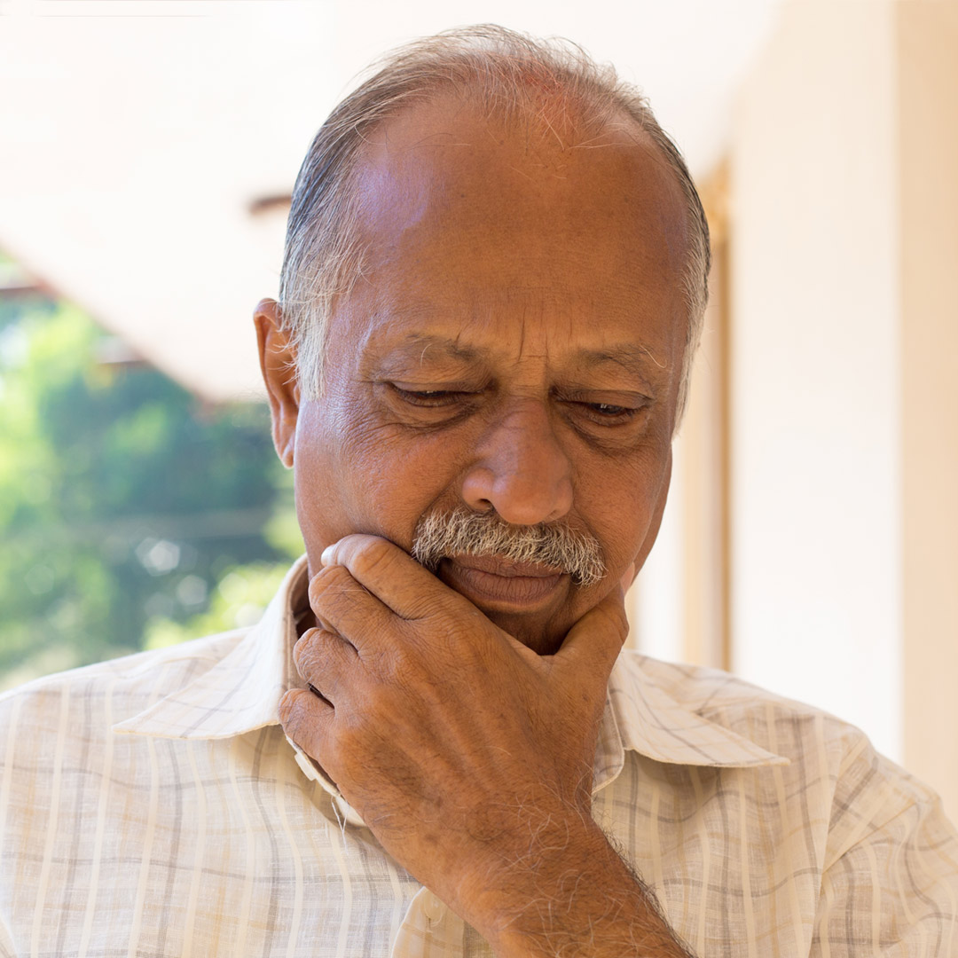 Understanding-Memory-Loss-symptoms man looking down and holding chin - thinking