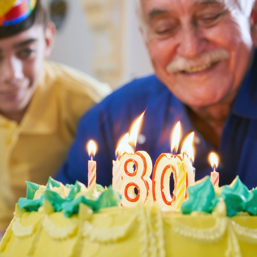 man celebrating 80th birthday with cake