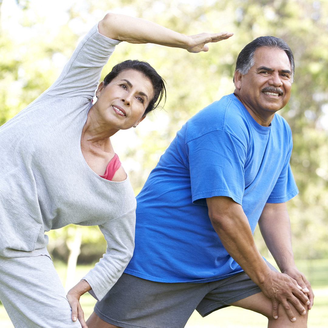 man and woman doing stretching exercises in the park