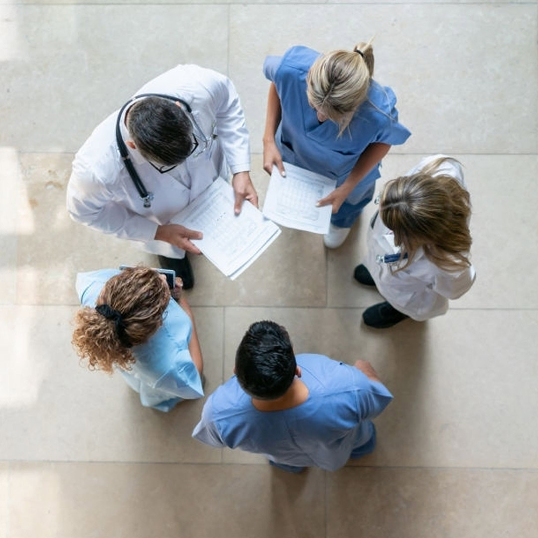 different healthcare workers standing in a circle as a team