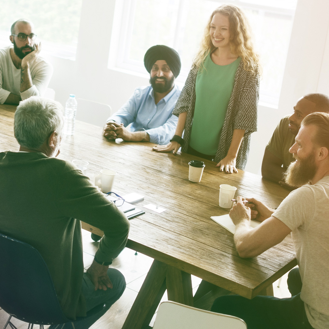 support-group-facilitator diverse group of people sitting at table and talking