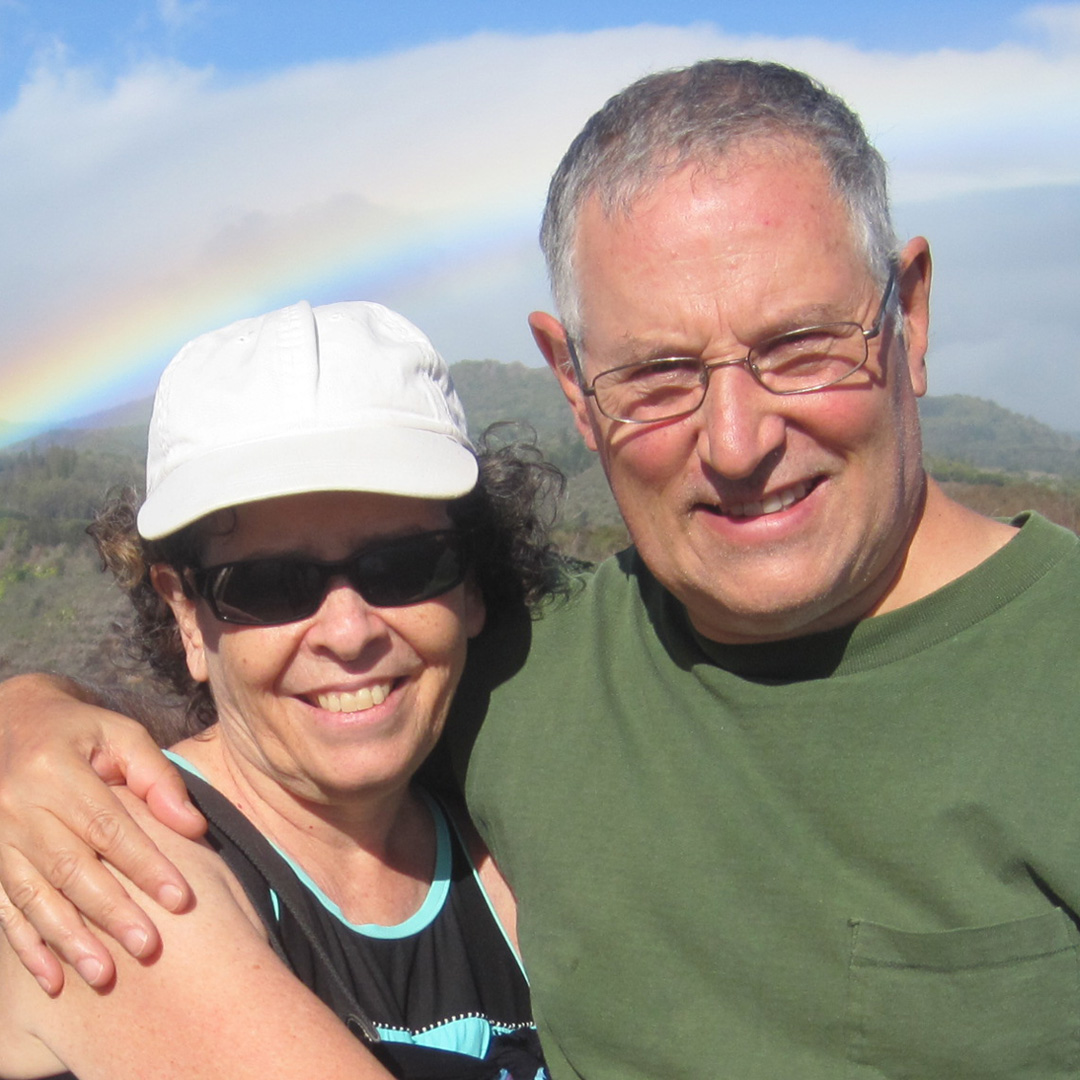 Deborah and Jeffrey in Hawaii with a rainbow in the background