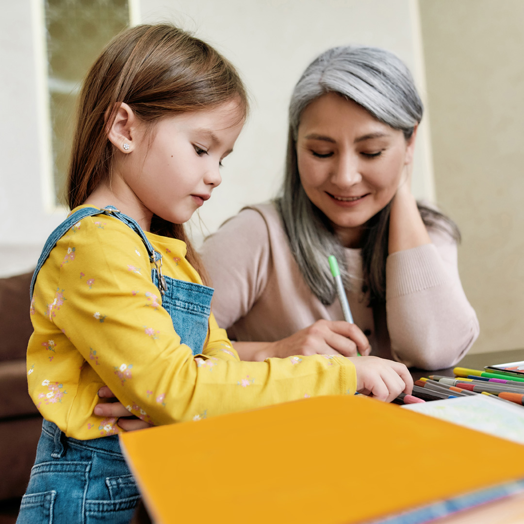 Grandmother drawing and coloring with granddaughter