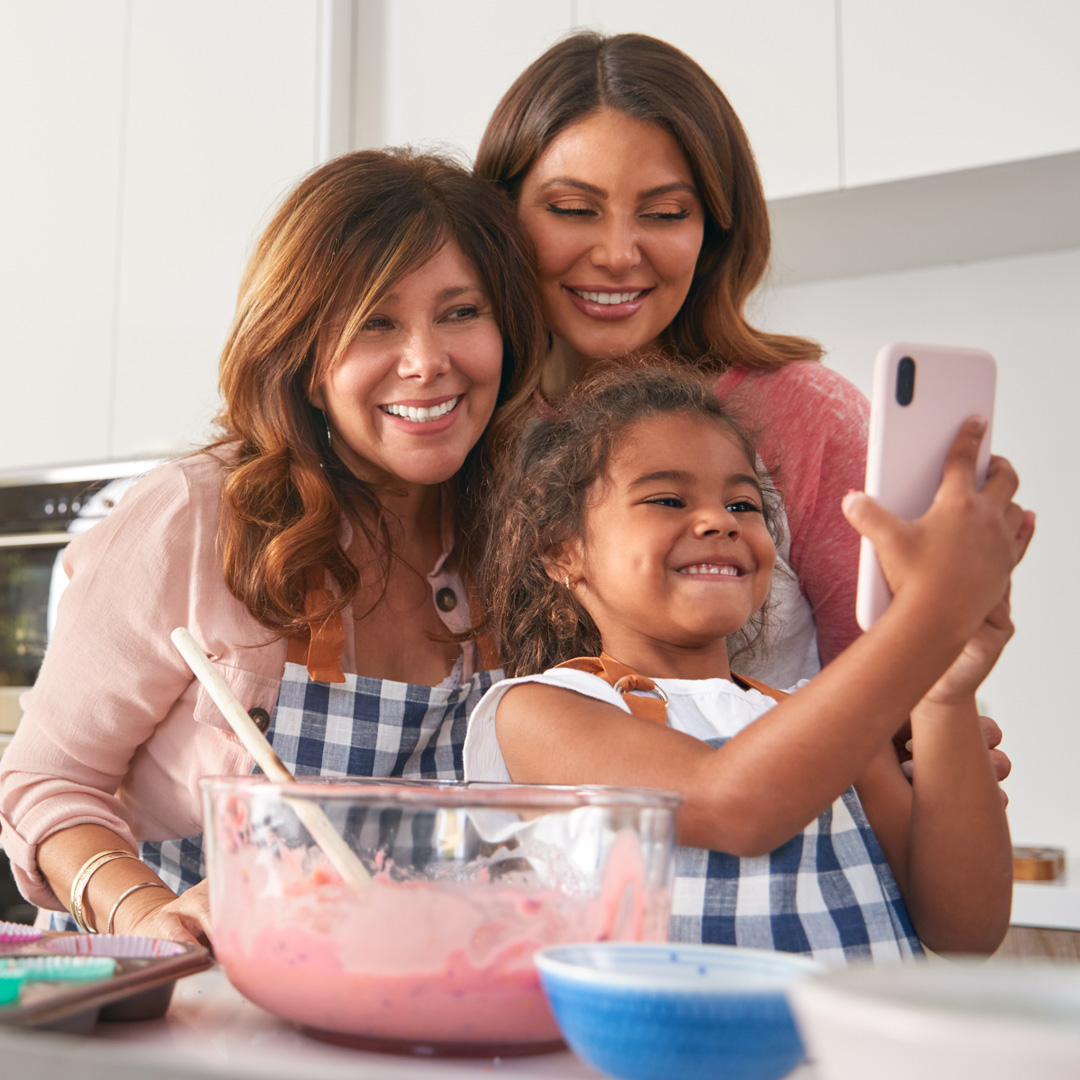 advocacy-state-families grandmother, mother, and granddaughter in kitchen taking a selfie