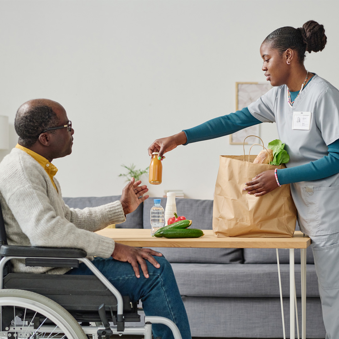 in-home professional caregiver unloading groceries for client