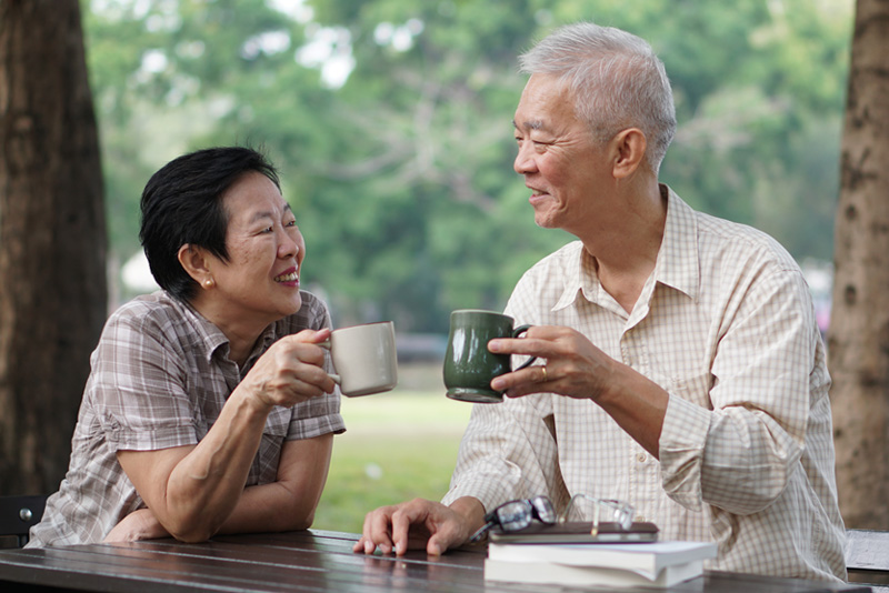 senior couple in park drinking coffee
