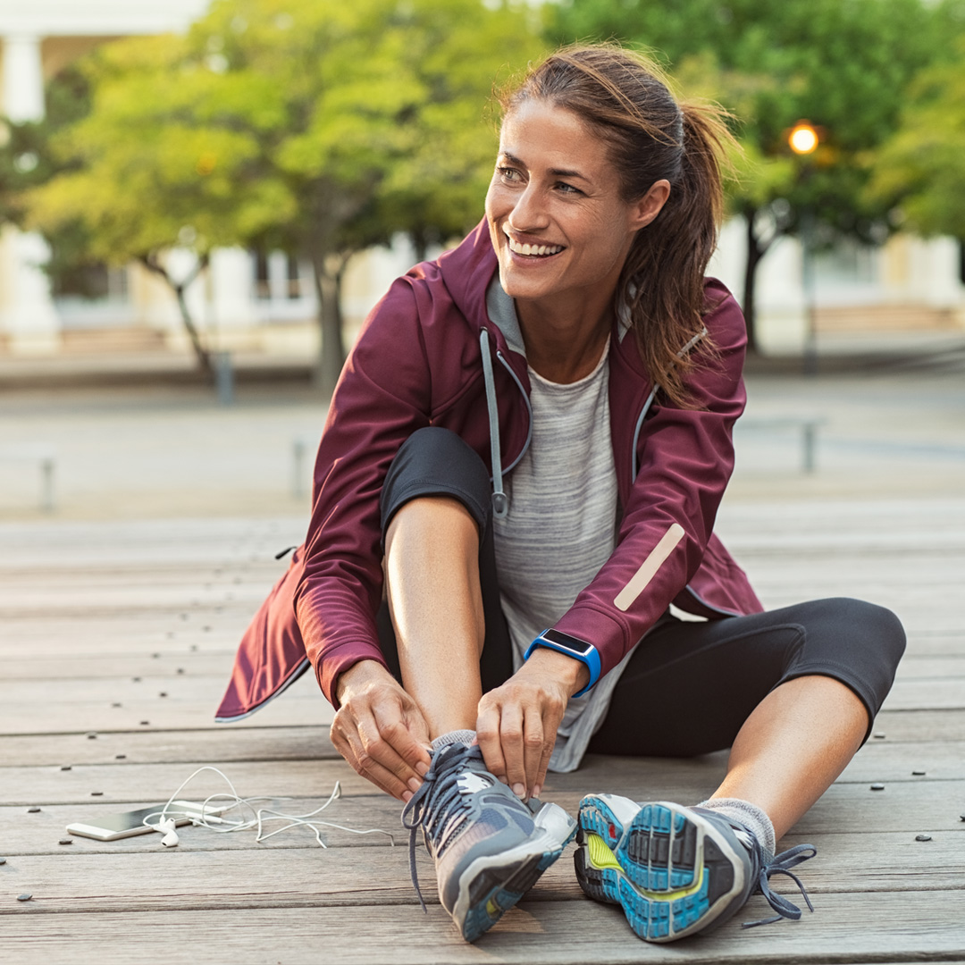 runner sitting down to adjust shoe