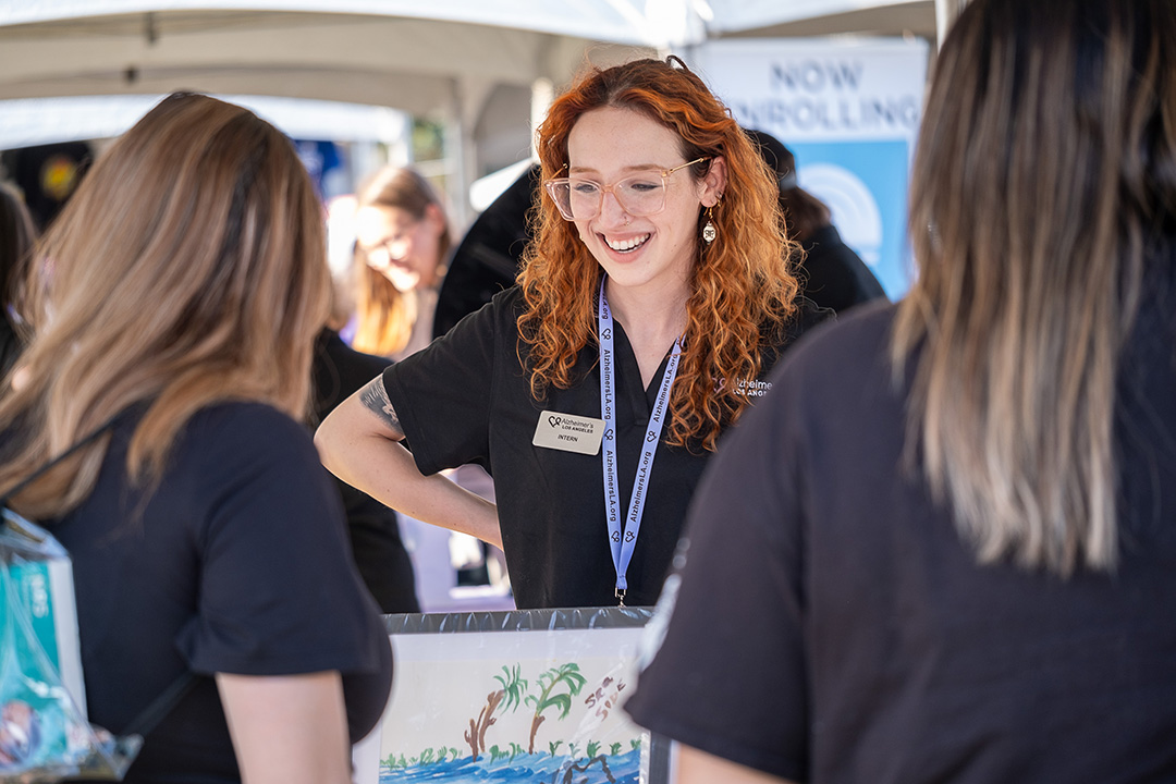 People talking at the Alzheimer's Los Angeles booth