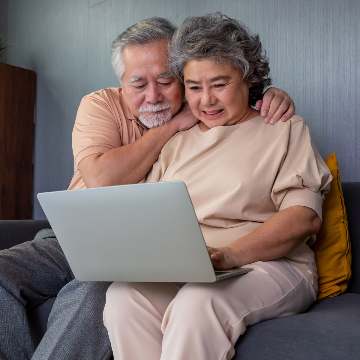 couple at home looking at a laptop screen, attending a virtual workshop