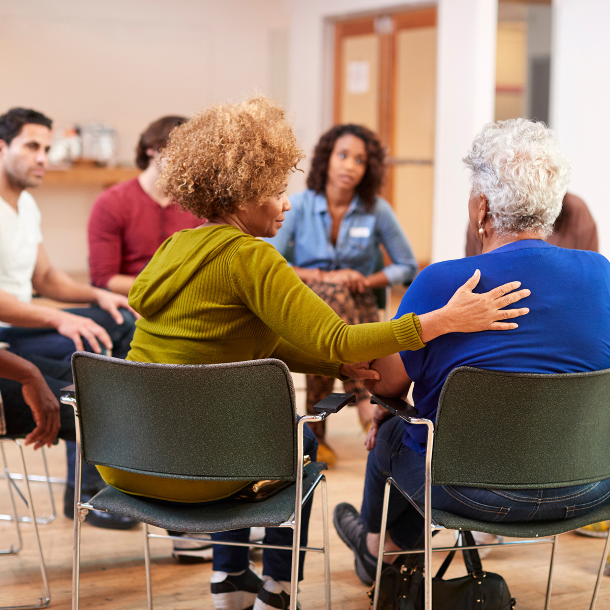 people sitting in a circle and talking as a support group