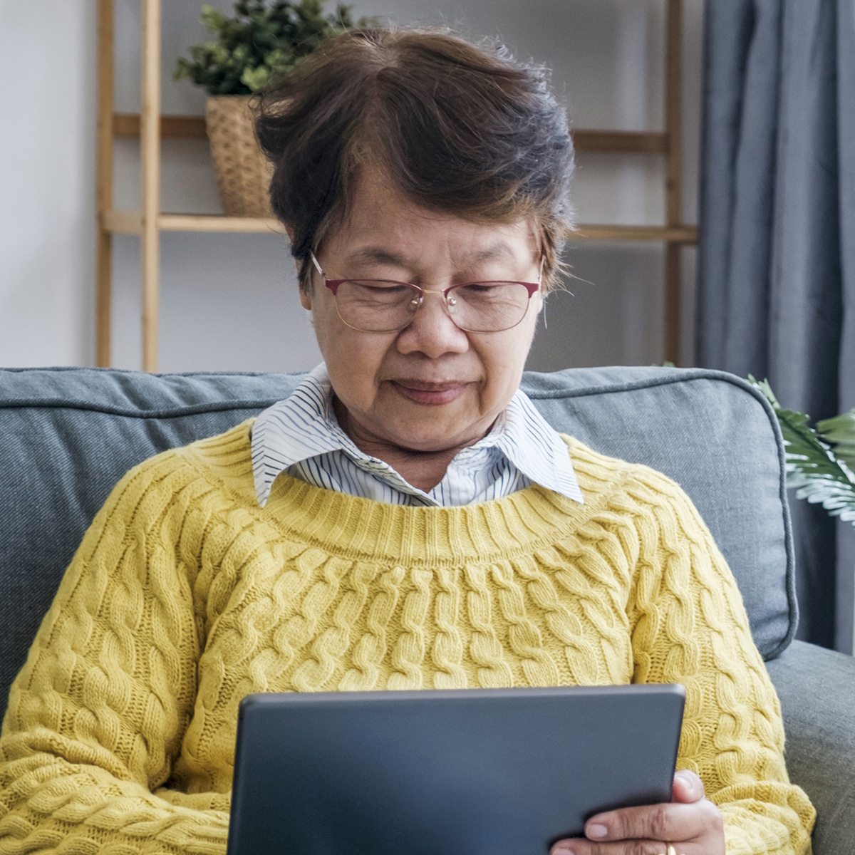 woman looking at a tablet and attending a video support group