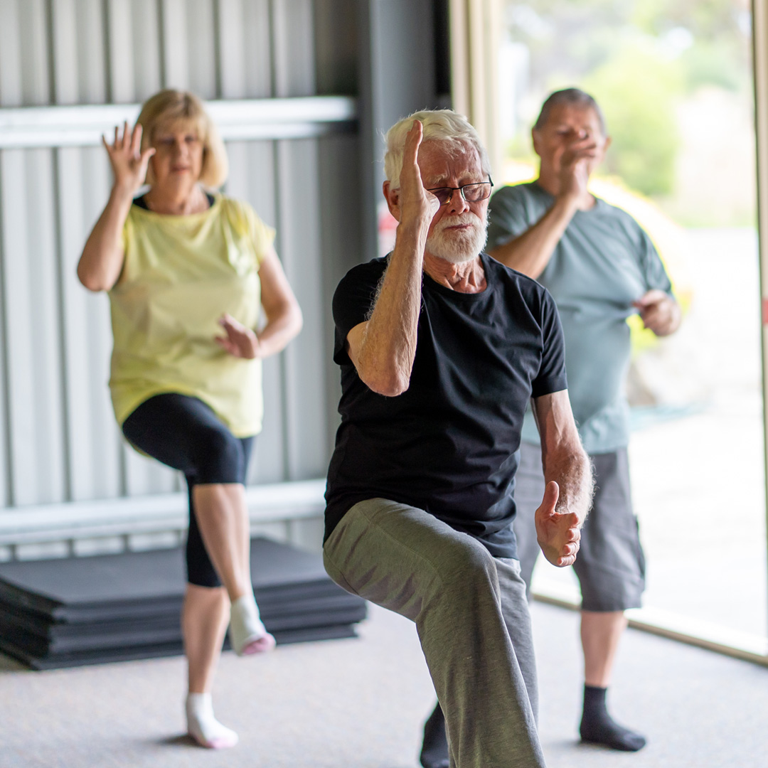 people taking tai chi class in a gym