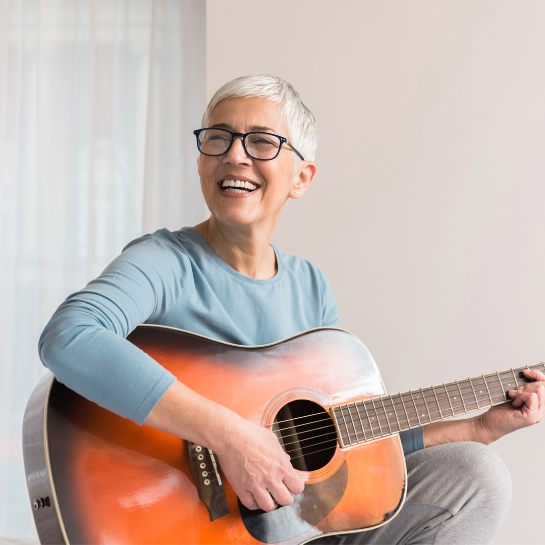 Care4ALZ-learn-musical-instrument woman learning to play a guitar