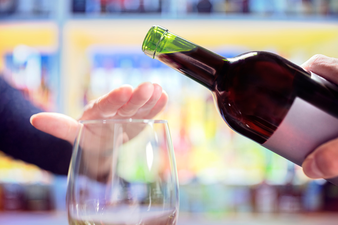 Care4ALZ-limit-alcohol woman putting hand over wine glass signaling no more wine to waiter