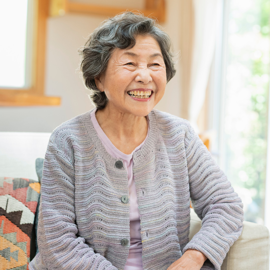 Care4ALZ-maximize-mood woman sitting on couch and smiling