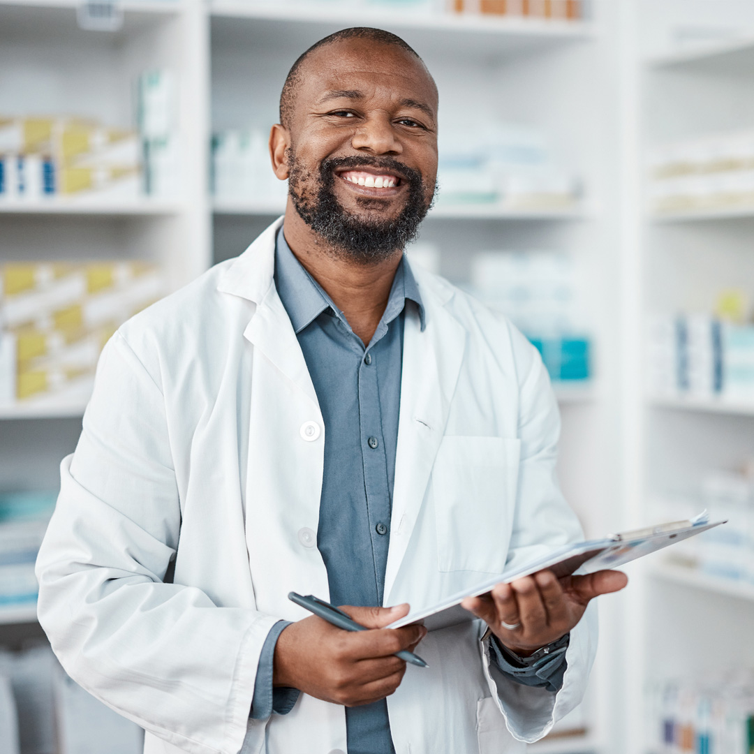 ECM-pharmacist pharmacist standing in the pharmacy smiling