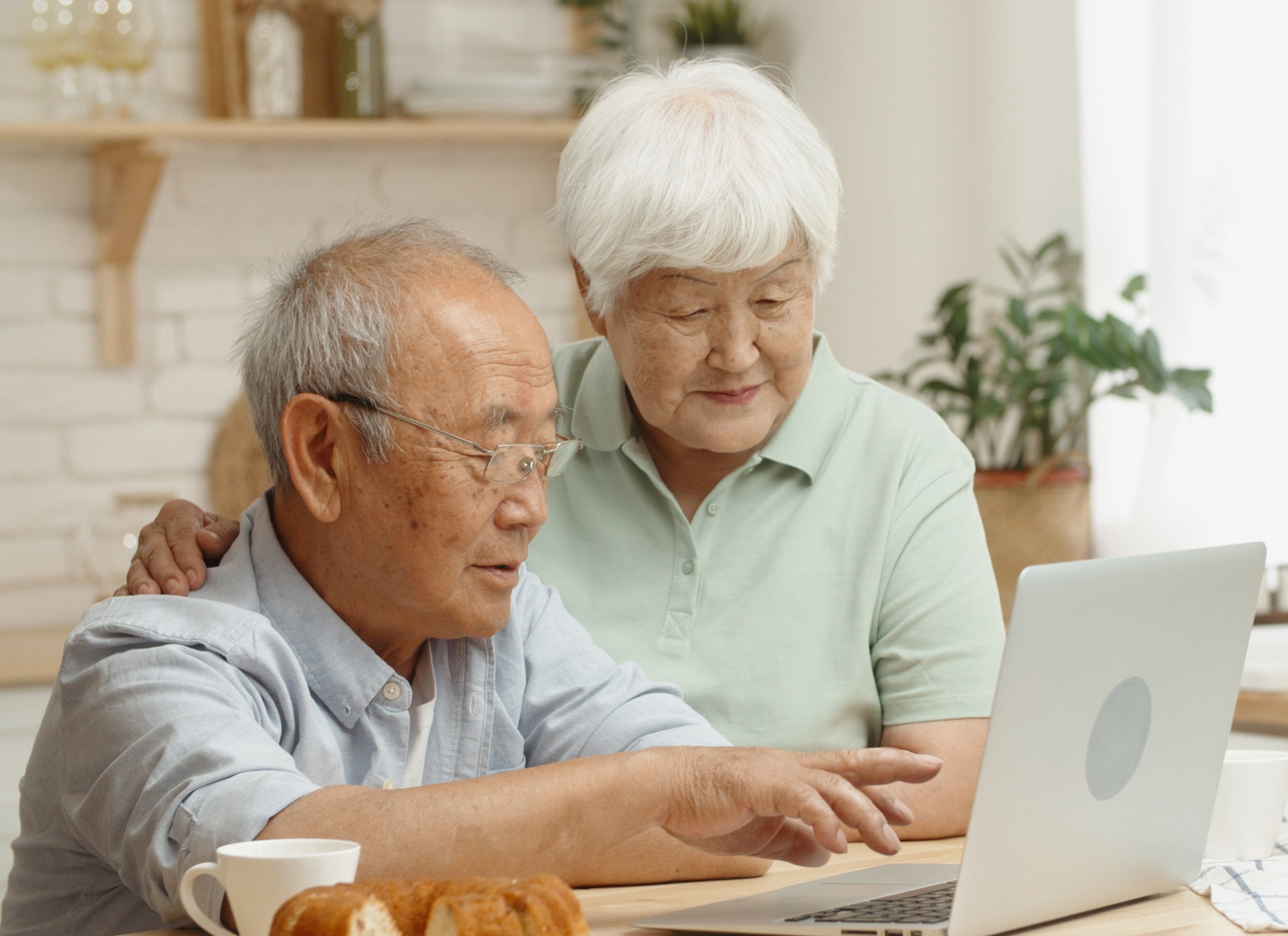 a couple at home in front of a computer attending a meeting online