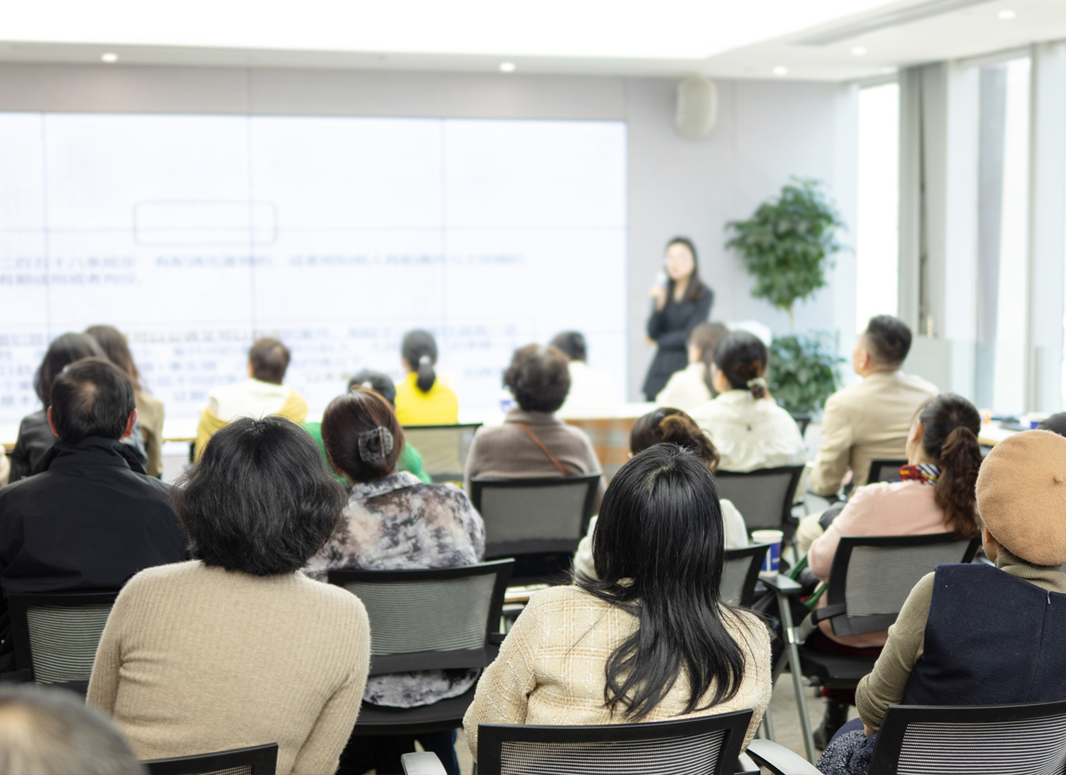 woman presenting a workshop in front of a group of adults